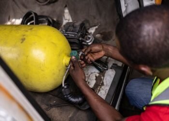 Jide Fashetire, Founder of City Mechanic, sets up a gas bottle in a minibus to convert it to gas combustion in City Mechanic, a Compressed Natural Gas (CNG) centre in Lagos, on November 12, 2024. (Photo by OLYMPIA DE MAISMONT / AFP)