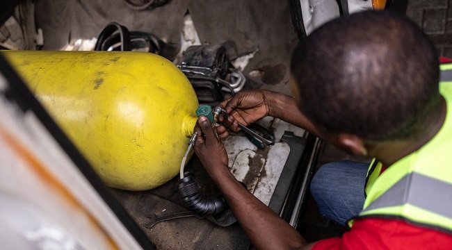 Jide Fashetire, Founder of City Mechanic, sets up a gas bottle in a minibus to convert it to gas combustion in City Mechanic, a Compressed Natural Gas (CNG) centre in Lagos, on November 12, 2024. (Photo by OLYMPIA DE MAISMONT / AFP)
